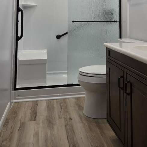 Modern full bathroom remodel in Newport Beach with a freestanding soaking tub, wood-style vanity, and custom tile work by CALbath Renovations.