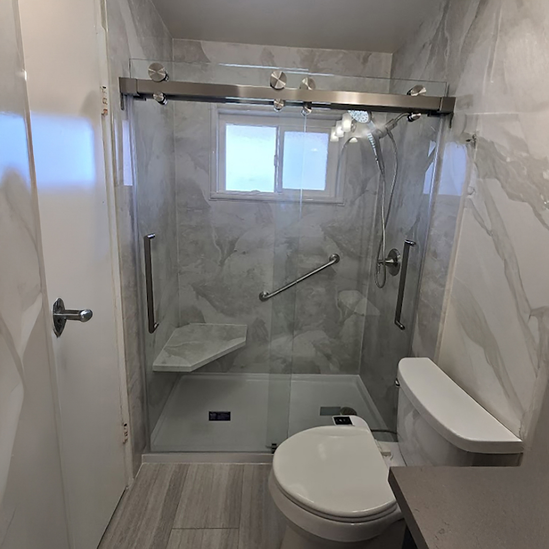 Modern full bathroom remodel in Newport Beach with a freestanding soaking tub, wood-style vanity, and custom tile work by CALbath Renovations.