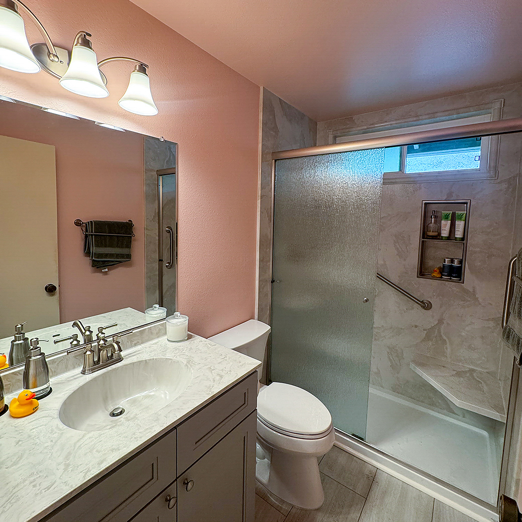 A stunning full bathroom remodel in Tustin, CA, by CALbath Renovations, featuring a floating double vanity, quartz countertops, and a spacious walk-in shower.