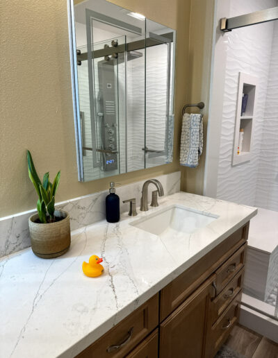 Bright Fullerton bathroom renovation with white acrylic walls and chrome fixtures by CALbath Renovations