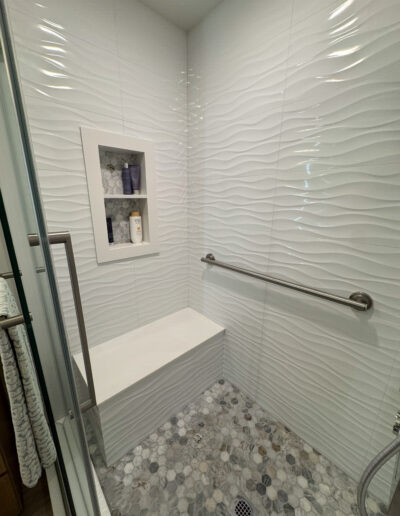 Walk-in shower with grout-free acrylic walls in an Orange, CA home by CALbath Renovations