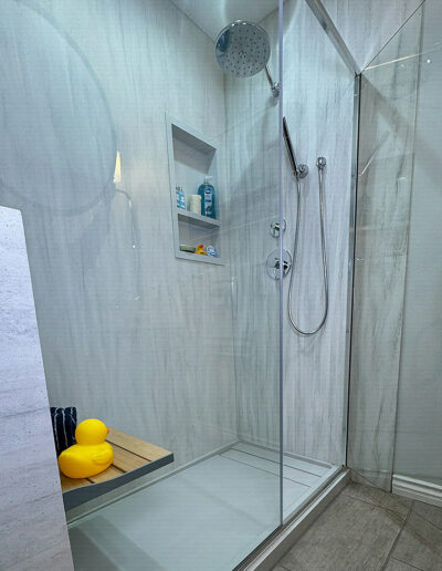 Curbless walk-in shower with a linear drain and seamless acrylic surround by CALbath Renovations