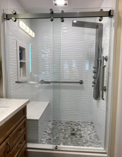 Bright bathroom remodel with white acrylic walls and brushed nickel fixtures by CALbath Renovations
