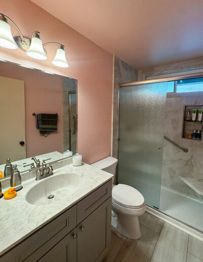 Walk-in shower with decorative tile accent and built-in storage niche